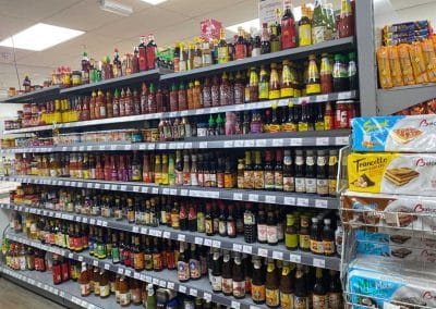 Asian Supermarket shelves and freezers, stocked with sauces.